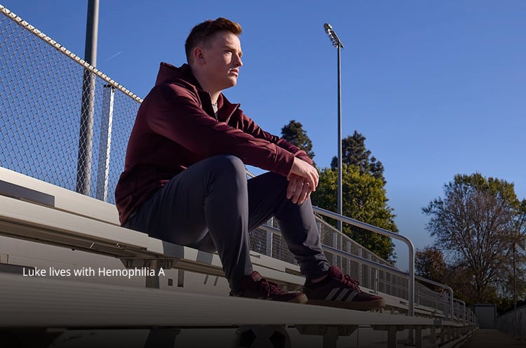 person sitting on bleachers outdoors looking into the distance